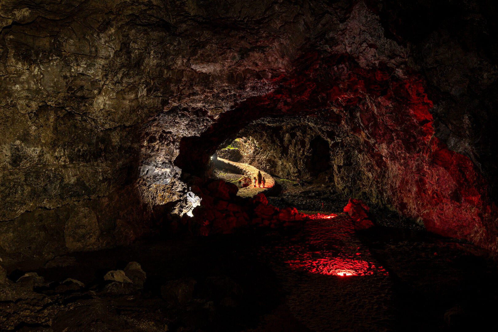 The Grotta volcanic cave glowing red as guests walk through