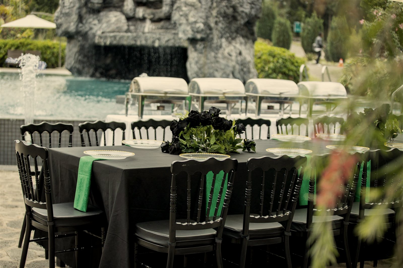 A long table set for a shared meal beside the rock waterfall at Grotta Resort